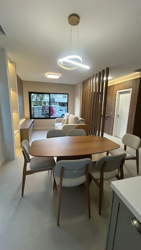 Mesa de jantar com cadeiras estofadas e luminária pendente em ambiente montado na Art's Colchões, Ingleses Florianópolis